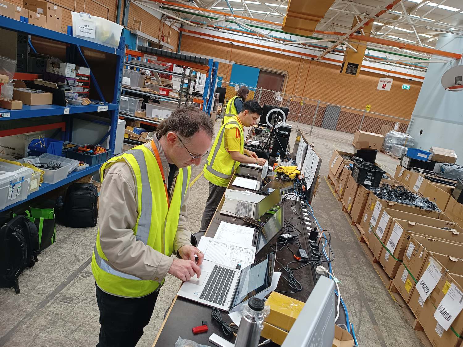 Volunteers testing laptops at the build bench in our Broadmeadows warehouse